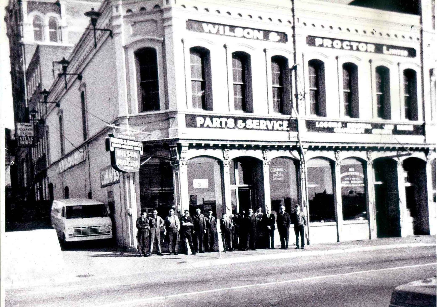 The staff of Wilson & Proctor Ltd. in front of 1129 Wharf Street on 26 March 1970. This photo shows company founders Howard Wilson (second from right) and Bob Proctor (third from right). Wilson & Proctor moved from this location in 1972. (Photo courtesy of Wilson &