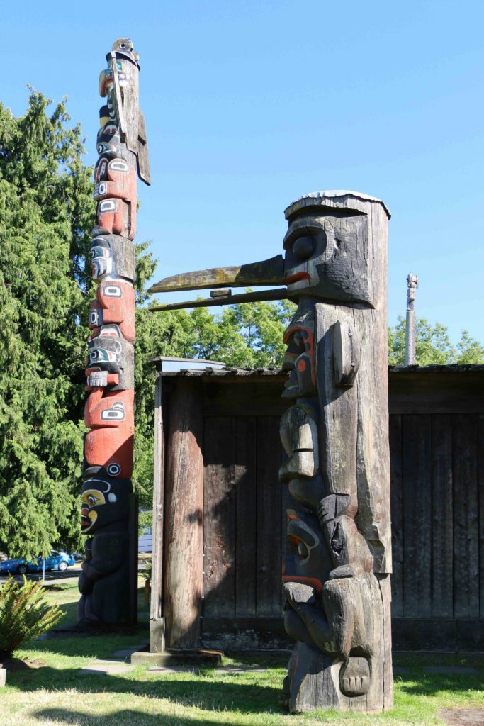 The Kwakwaka'walw Heraldic Pole (left) was carved in 1953. The Kwakwaka'walw Pole (right) was carved in 1954. (photo by Victoria Online Sightseeing Tours)